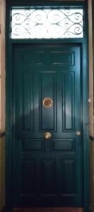 Puerta de entrada castellana verde con verja negra superior